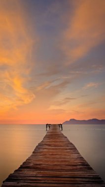 Ahşap iskele/Jetty, Playa de Muro, Alcudia, gündoğumu, dağlar, gözlerden uzak plaj, altın güneş ışığı, yansıma, güzel gökyüzü, bulutlar, dönüm noktası, Mallorca, İspanya.