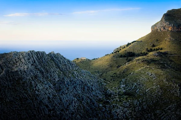 Tramuntana perto de Sa Calobra, casa solitária nas montanhas ao pôr do sol, rochas, pastos verdes, mar mediterrâneo, céu azul, Maiorca, Espanha . — Fotografia de Stock