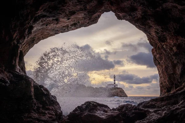 Farol de Portocolom, caverna de pedra natural, mar azul com onda e spray de mar, Maiorca, Espanha . — Fotografia de Stock
