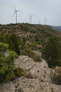 Tepeler ve yel değirmenleri ile bulutlu gökyüzü