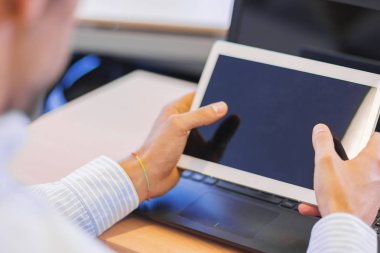 Bazı elektronik cihazlarla masada çalışan işadamı