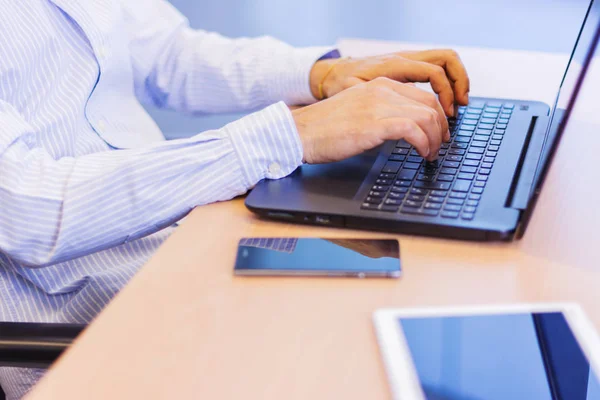 Bazı elektronik cihazlarla masada çalışan işadamı