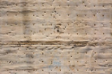 Eski lekeli, dövülmüş ve paslı metal panel. Kapıda çiviler var. Arkaplan veya tasarımlar için resim