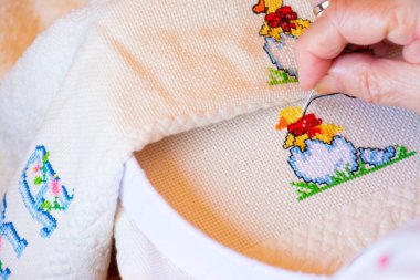 Kadınlar renkli çapraz ilmek tasarımı için hayvanlarla ve harflerle siyah detaylar yaratıyor. El işi kavramları ya da evde çalışma.