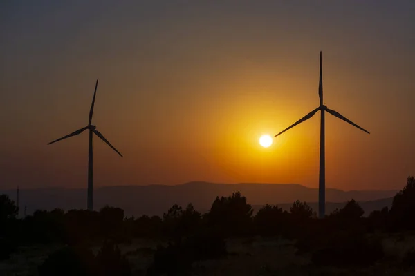 Zwei Windmühlentürme Mit Bergen Und Orangefarbenem Himmel Von Sonnenuntergang Oder — Stockfoto