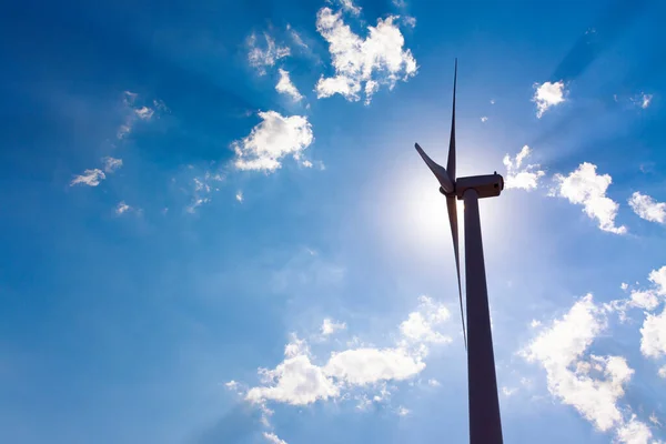 风车塔的背光 发动机后面是太阳 蓝天乌云 阳光灿烂 清洁能源 气候变化和生态概念 — 图库照片