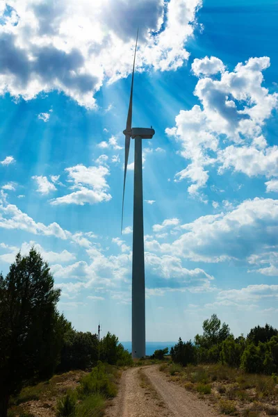 Weg Einem Hinterleuchteten Windmühlenturm Mit Wolken Blauen Himmel Und Sonnenstrahlen — Stockfoto