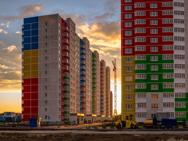 Construction crane and building under construction. Construction site. Construction crane and bright colored high-rise building on the background of a beautiful cloudy evening sky — Stock Image Construction Crane Building Construction Construction Site Construction Crane Bright Colored Stock Image