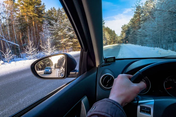 stock image Driving SUV car in winter on forest road with much snow. rearview mirror. the car goes to overtake. auto makes overtaking.road view from inside the car