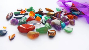 Çeşitli doğal parlak renkli yarı değerli taşlar ve çanta beyaz arka plan üzerinde mücevher