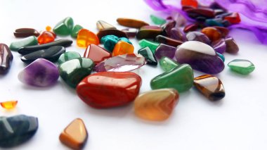 Çeşitli doğal parlak renkli yarı değerli taşlar ve çanta beyaz arka plan üzerinde mücevher