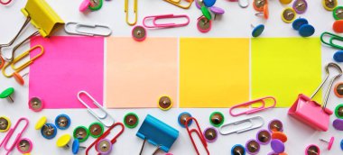 Geri okul, ofis, iş ve eğitim kavramı için renkli sabit. Okul ve ofis malzemeleri ataç, iğne, notlar, beyaz arka plan, flatlay çıkartmaları. Kadar alay et. Görünümü en çok, yakın çekim.