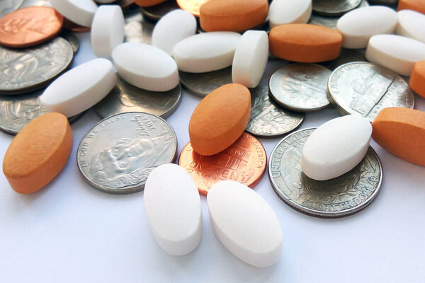 Таблетки, таблетки и капсулы с американскими монетами на долларовом фоне США. Аптека и деньги тема, здравоохранение, рецепт лекарств для лечения лекарств
