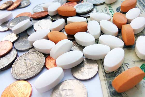 Таблетки, таблетки и капсулы с американскими монетами на долларовом фоне США. Аптека и деньги тема, здравоохранение, рецепт лекарств для лечения лекарств
