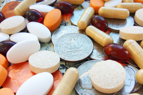 Таблетки, таблетки и капсулы с американскими монетами на белом фоне. Аптека и деньги тема, здравоохранение, рецепт лекарств для лечения лекарств
