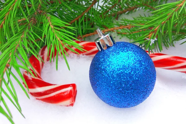 Blaue Silvesterkugel Und Weihnachtliche Karamellbonbons Mit Grünem Tannenbaum Auf Schneebedecktem — Stockfoto