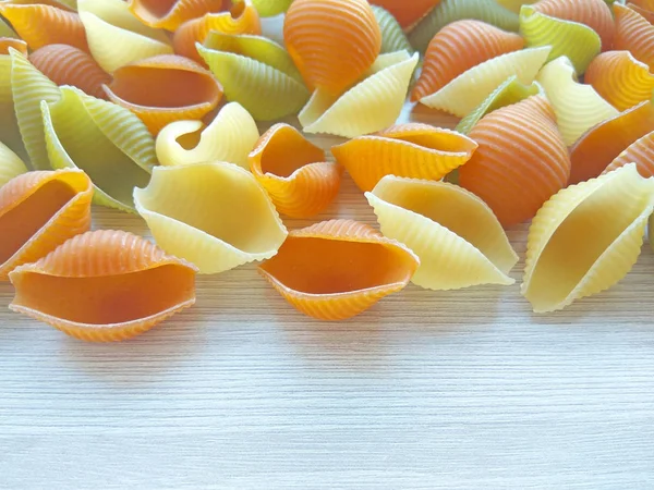 Getextureerde Italiaans Eten Achtergrond Kleurrijke Ongekookt Conchiglie Pasta Houten Tafel — Stockfoto