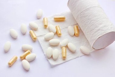 Pills, capsules and tablets with toilet paper on light background. Pharmacy and medicine concept. Focused on a pharmaceutical industry for diarrhea and constipation clipart