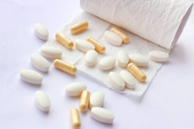 Haplar, kapsüller ve tabletler, hafif arka planda tuvalet kağıdı. Eczacılık ve tıp konsepti. İshal ve kabızlık için bir ilaç endüstrisi odaklanmış