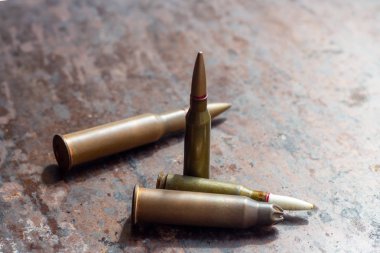 Paslı metal arka planda silah mermileri. Askeri sanayi, savaş, küresel silah ticareti ve suç kavramı.