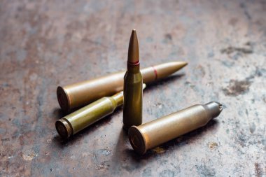 Paslı metal arka planda silah mermileri. Askeri sanayi, savaş, küresel silah ticareti ve suç kavramı