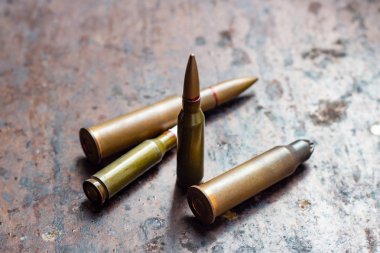 Paslı metal arka planda çeşitli silah mermileri. Askeri sanayi, savaş, küresel silah ticareti ve suç kavramı