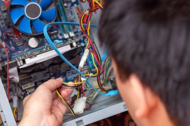 Genç teknisyen elindeki bilgisayarı onarmak için tornavidayı tutuyor. Bilgisayar donanımı, servis, yükseltme ve teknoloji onarım konsepti