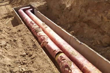 Dağıtım ünitesi ısıtma ağının kurulumu. Toprak çukurundaki boruları bağlamak için çerçeve.