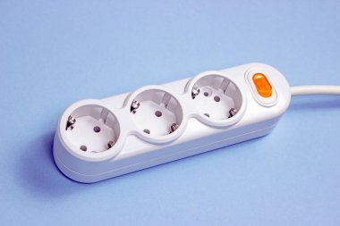 Evinde farklı kablolar bulunan üçlü soket beyaz Avrupa güç adaptörü. Mavi arkaplanda standart elektrik prizi prizi prizi