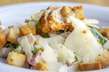 Büyük beyaz tabakta ızgara tavuk göğsü ile taze sağlıklı Sezar salatası..