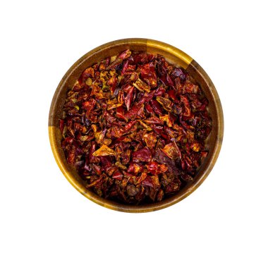 Beyaz arka planda izole edilmiş yuvarlak ahşap bir kasede kırmızı biber dilimlerinin üst görüntüsü..