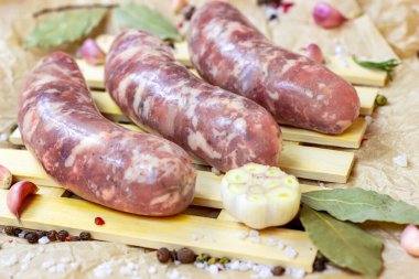 Taze pişmemiş ev yapımı domuz sosisi sarımsaklı ve baharatlı mutfakta ahşap arka planda..