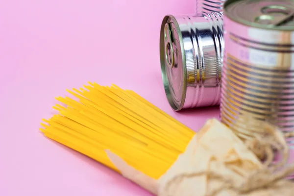 罐头食品 金属罐和黄色意大利面 粉红背景 有复制空间 食品捐赠 慈善和送货概念 — 图库照片