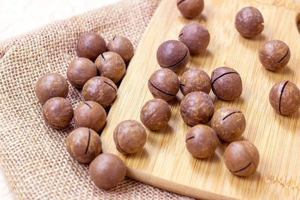 Brown Macadamia Nuts Wooden Cutting Board Light Textile Background — Stock Photo, Image