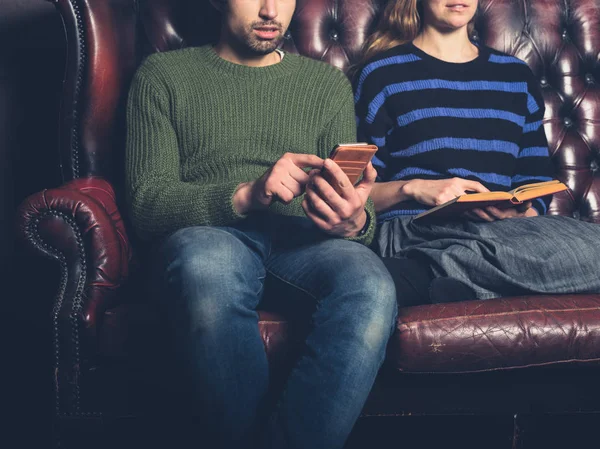 Ein Junges Paar Auf Dem Heimischen Sofa Liest Und Benutzt — Stockfoto