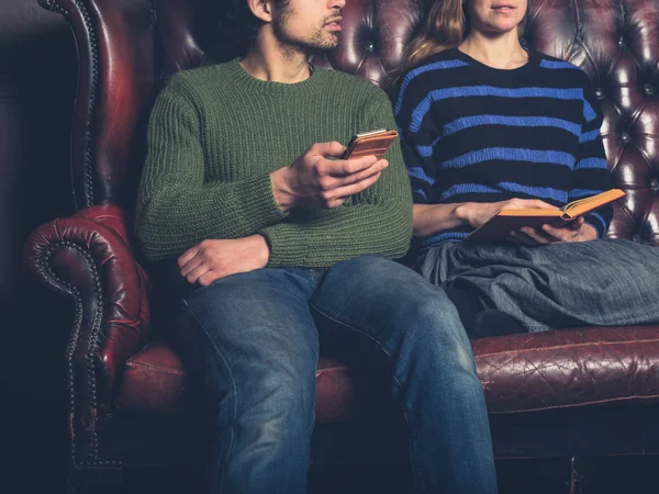 Een Jong Koppel Een Sofa Thuis Zijn Lezing Het Gebruik — Stockfoto