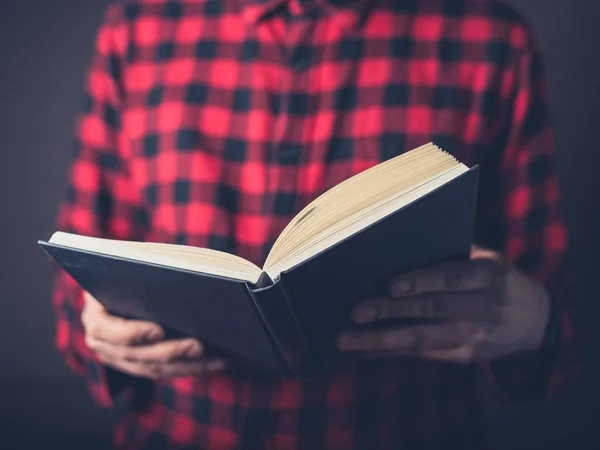 Ένας Νεαρός Άνδρας Φορώντας Ένα Πουκάμισο Φανέλα Διαβάζοντας Ένα Βιβλίο — Φωτογραφία Αρχείου