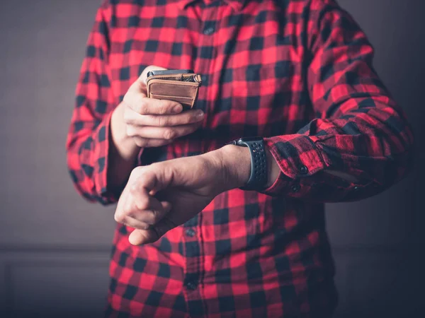 Ein Junger Mann Rotem Flanellhemd Ist Mit Smartphone Und Armbanduhr — Stockfoto