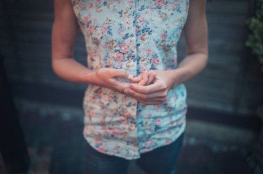 Sinir bir genç kadın bahçede tırnaklarını alıyor