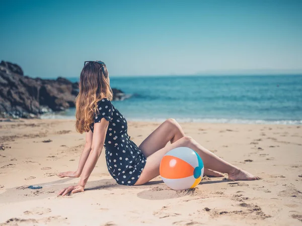 Μια Νεαρή Γυναίκα Είναι Χαλαρώνοντας Στην Παραλία Μια Μπάλα Παραλία — Φωτογραφία Αρχείου
