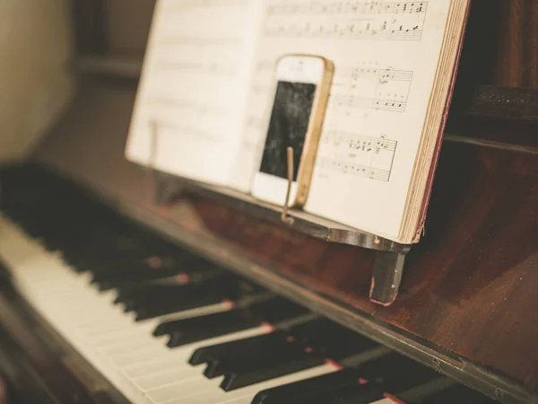 Ein Smartphone Auf Einem Klavier Mit Notenpapier — Stockfoto