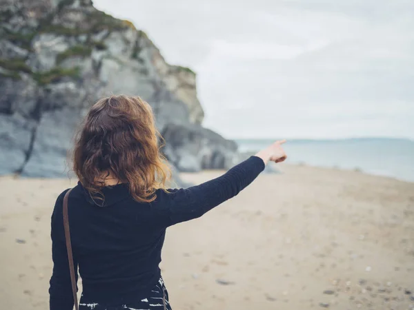 Ung Kvinna Står Stranden Och Riktade Mot Havet — Stockfoto
