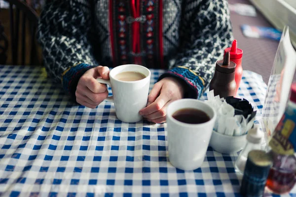 カフェのテーブルに座って お茶のカップを持っている若い女性の手のクローズ アップ — ストック写真