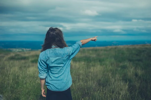 Een Jonge Vrouw Staat Een Heuveltop Wijst — Stockfoto