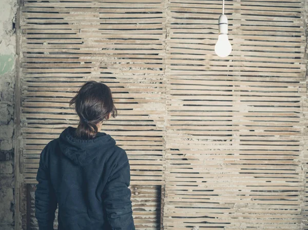 Eine Junge Frau Steht Unter Einer Glühbirne Einer Alten Wand — Stockfoto