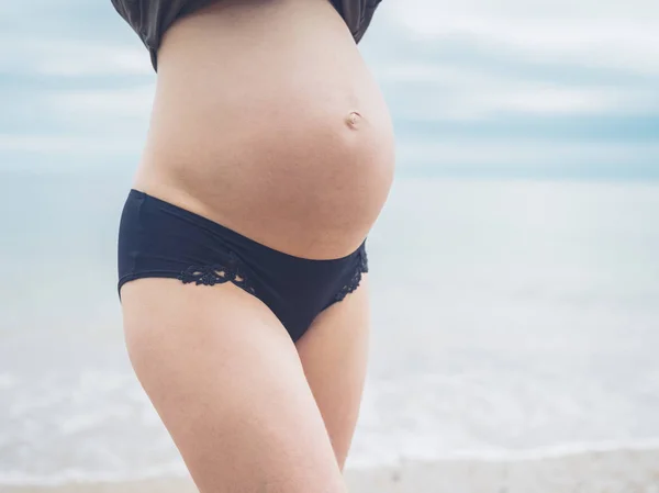Una Mujer Embarazada Joven Está Pie Playa Está Mostrando Protuberancia —  Fotos de Stock