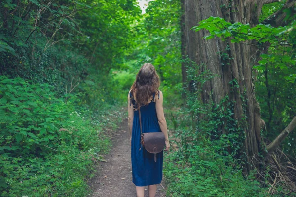 一名年轻女子走在一片森林 — 图库照片