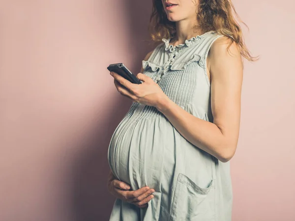 Młoda Kobieta Ciąży Jest Korzystania Telefonu Komórkowego — Zdjęcie stockowe