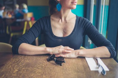 Stitting bir restoranda bir masada genç bir kadındır