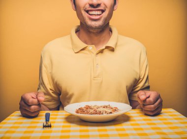 Genç bir adam sarı fonunda kıymalı yemek